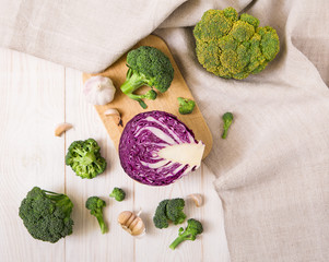 Fresh red cabbage,broccoli and garlic.white wooden table with tablecloth.top view