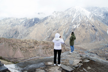 Туристы смотрят на горы Грузии. Высоко в горах 