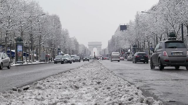 The arc de triumph by a rare snowy day in Paris, France