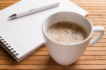 Workplace with a pen, notepad, a cup of coffee. Freelancer work space. Top view