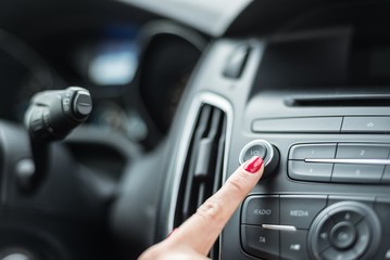 Woman turning on car radio