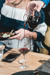 sommelier pouring champagne into glass at wine tasting