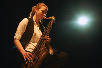 Fototapeta na wymiar The girl playing the saxophone