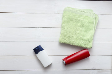 Composition with plastic bottles and towel of body care and beauty products top view flat lay