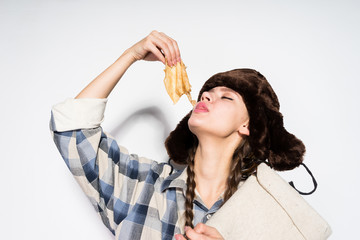 Russian girl with hat eating delicious pancakes