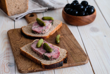 Sandwich with rye bread, a ham and a salted cucumber.