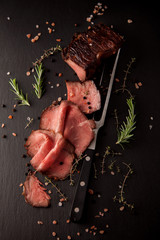 Sliced medium rare grilled roast beef ribeye steak on dark slate kitchen plate background - 196496194