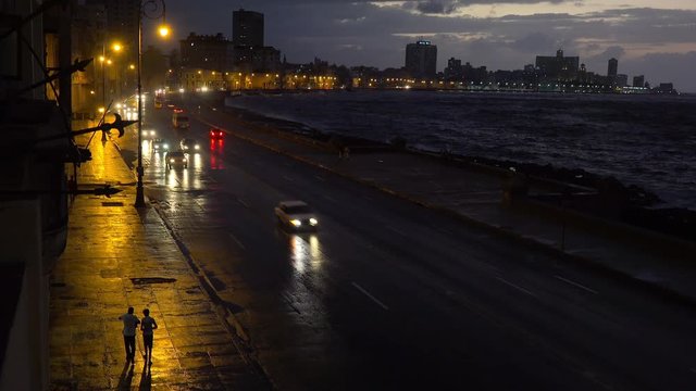 Beautiful night shot of the malecon in Havana Cuba with cars passing.
