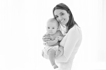 Mother, holding her sick baby boy, sad baby, isolated on white
