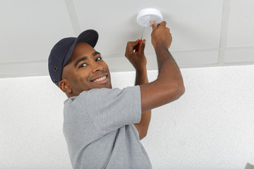 Man fitting smoke detector