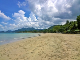 Blue sky and clouds over a tropical beach with green palm trees on Koh Chang island in Thailand
