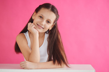 Teen girl model on pink background in white tank top