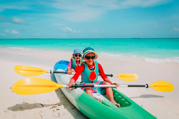 cute little boy and girl kayaking at beach