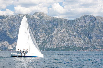 Naklejka premium Sailboat on lconstance upwind on blue wateron on boka bay