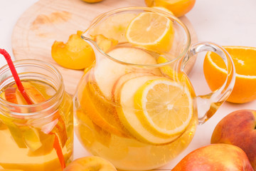 Pitcher of cool lemonade with homemade apple and citrus fruit closeup