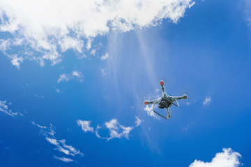 Naklejka na ściany i meble flying drone with camera on the blue sky