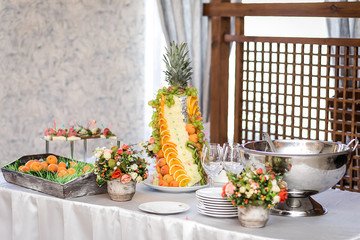 fruit on a plate strawberry grapes, orange and pineapple, kiwi.