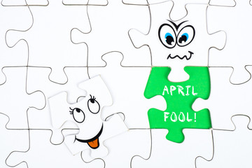 Puzzle pieces with a funny face and the words april fools
