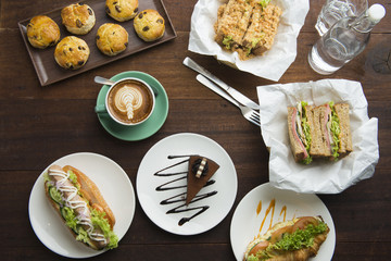 Different types of coffee and food on dark table, top view