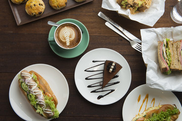 Different types of coffee and food on dark table, top view