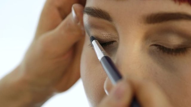 Close-up of professional make-up artist doing everyday makeup, puts powder on womans cheeks with brush