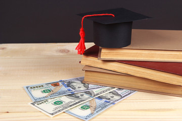 Graduation cap with book in front of black board