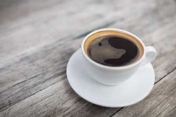 Hot black coffee on a wooden table.