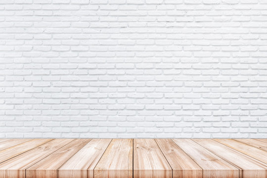 Empty wooden table top with white color brick wall background.