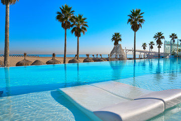 Fototapeta na wymiar Resort infinity pool in a beach with palm trees