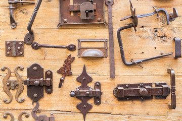 Different lockers, knobs and iron hinges on wooden door..