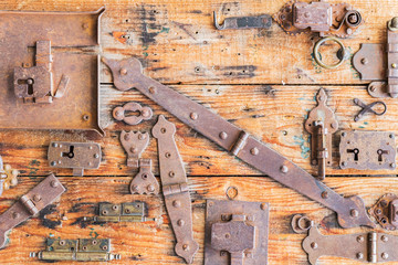 Different lockers, knobs and iron hinges on wooden door..