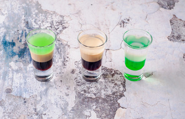 Set of strong alcoholic drink in shot glasses shooters, shots on background restaurant. Bar alcoholic cocktails menu into small glasses, long drink for party.