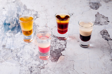 Set of strong alcoholic drink in shot glasses shooters, shots on background restaurant. Bar alcoholic cocktails menu into small glasses, long drink for party.