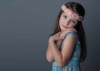 Studio shot of young girl with long brown hair and brown eyes