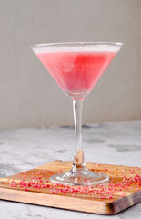 Top view red pink cocktail Margarita fresh in a martini glass on a wooden board, gray background. Bar alcohol drink menu, delicious tequila sunrise long drink.