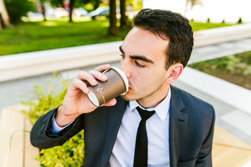 Young businessman take break to drink coffee outdoor
