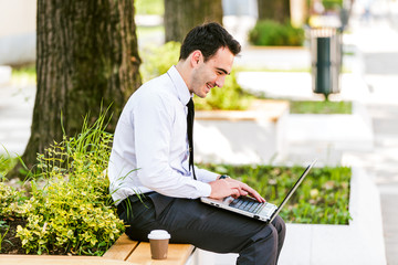 Happy businessman use laptop outdoor