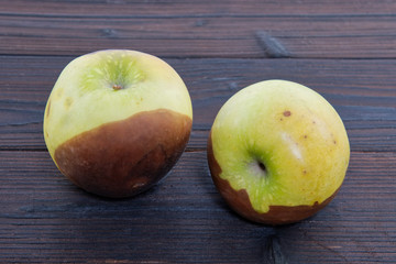 Rotten green apples on a table