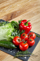 Organic closeup still life of assorted fresh vegetables and herbs on rustic wooden background, topview, selective focus.