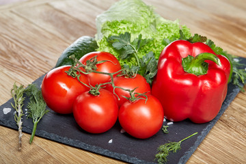 Organic closeup still life of assorted fresh vegetables and herbs on rustic wooden background, topview, selective focus.
