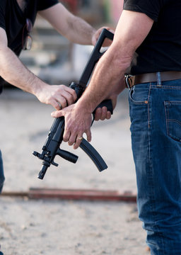 Cropped image of men holding a rifle