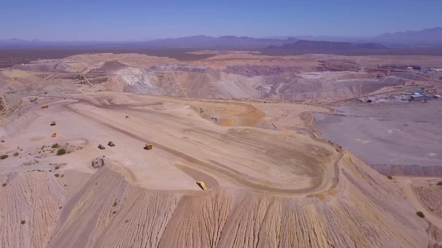 An aerial over a vast open pit strip mine in the Arizona desert.