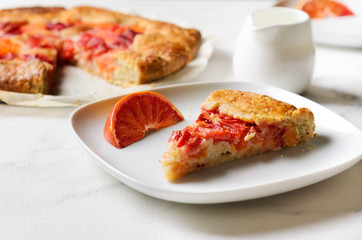 Piece of orange galette on marble table