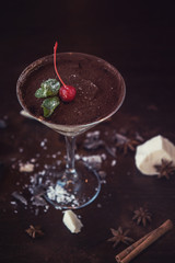 Ice cream chocolate dessert decorated with cherry on dark brown background