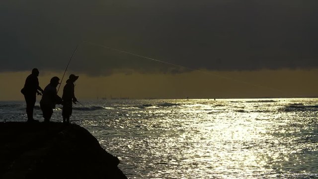 Three Fishermen Cast During Sunset At Ala Moana Beach Park In Honolulu, Hawaii