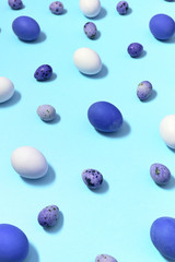 White, blue and quail easter eggs on blue background, copy space. Healthy food concept. Top view, flat lay. Happy Easter concept