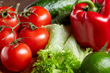 Close-up still life of assorted fresh vegetables and herbs on vintage wooden background, top view, selective focus.