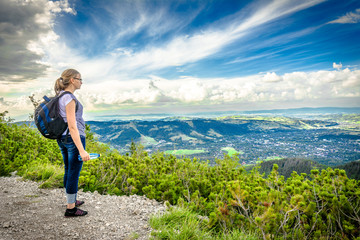 Hiking with backpack, hiker woman on top of the mountain, traveling people in mountains and success concept