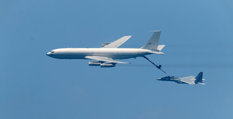 Israeli fighter jet and tanker in air refueling. The Jets flight from right to left in formation.