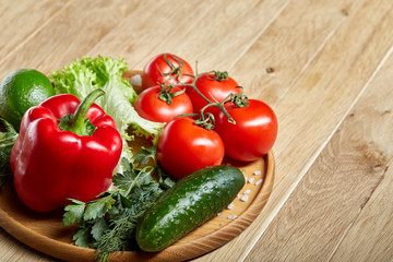Artistic still life of assorted fresh vegetables and herbs on rustic wooden background, top view, selective focus.